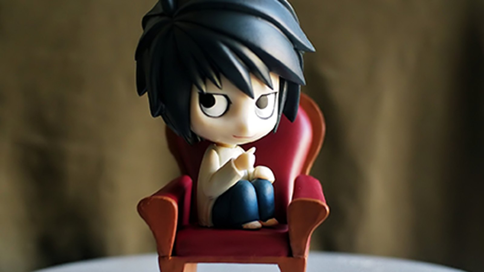 Figurine de personnage assise dans un fauteuil, pose d’étude pour l’animation